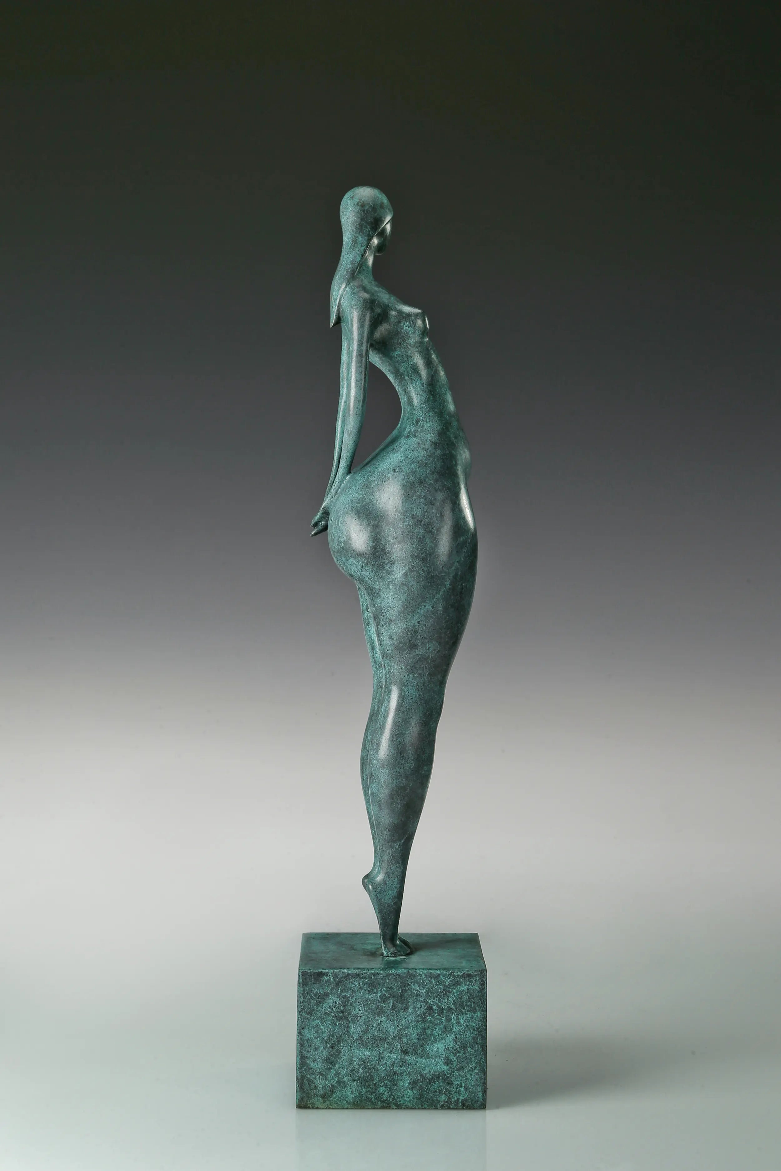 Side view of modern standing female figure bronze sculpture showing its slender waist and curved silhouette