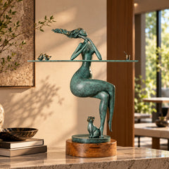 Abstract seated woman with birds and cat bronze sculpture displayed on a marble console in a warm modern interior