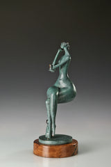Side view of the seated woman bronze statue showing her relaxed posture and wooden base