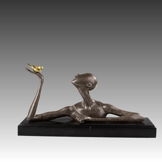 Front view of reclining abstract woman bronze sculpture looking at a golden bird on her raised hand