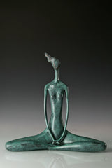 Full view of green bronze seated meditation sculpture with long slender arms
