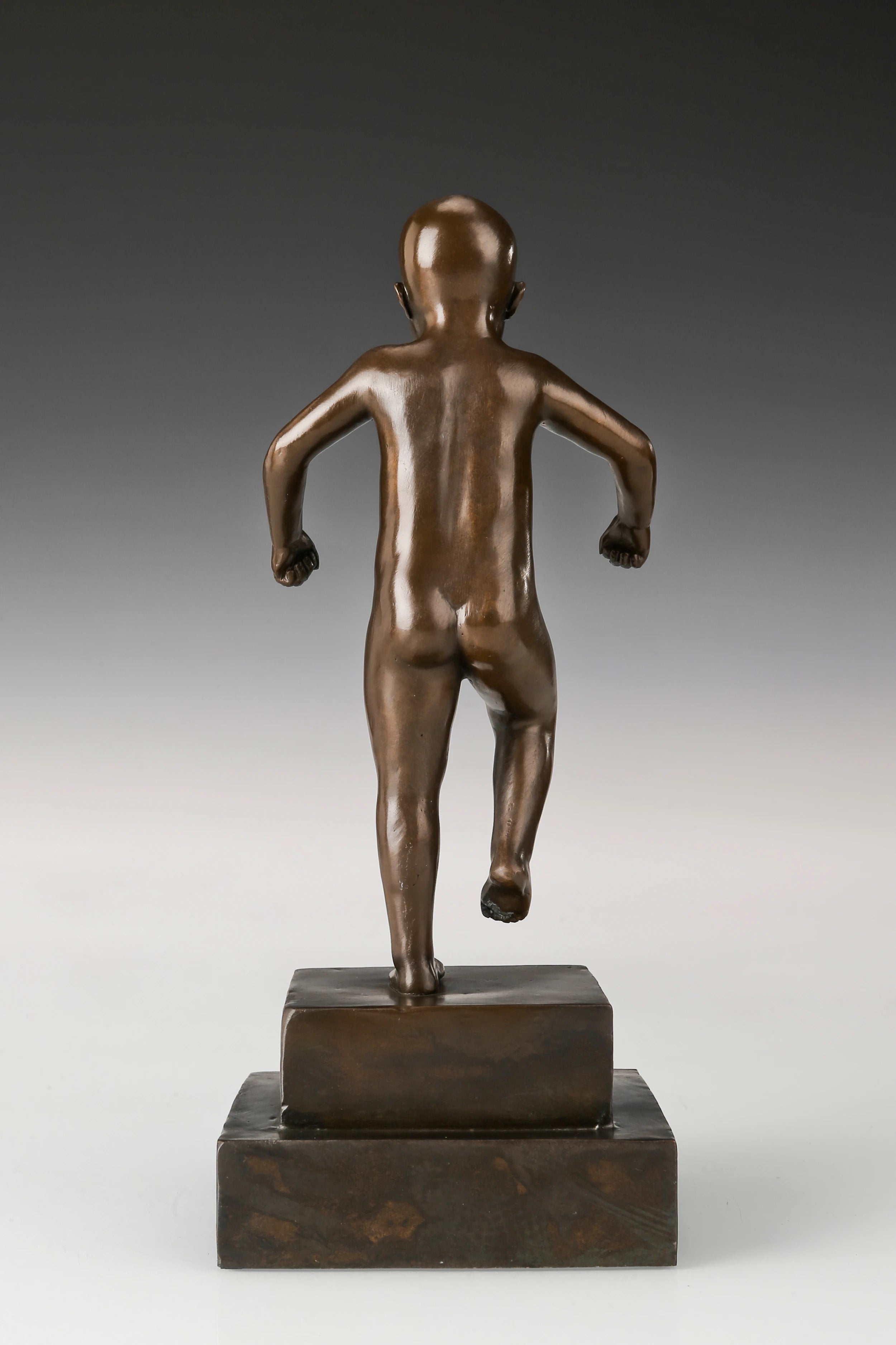 Rear view of handcrafted angry boy bronze sculpture showing full figurative form