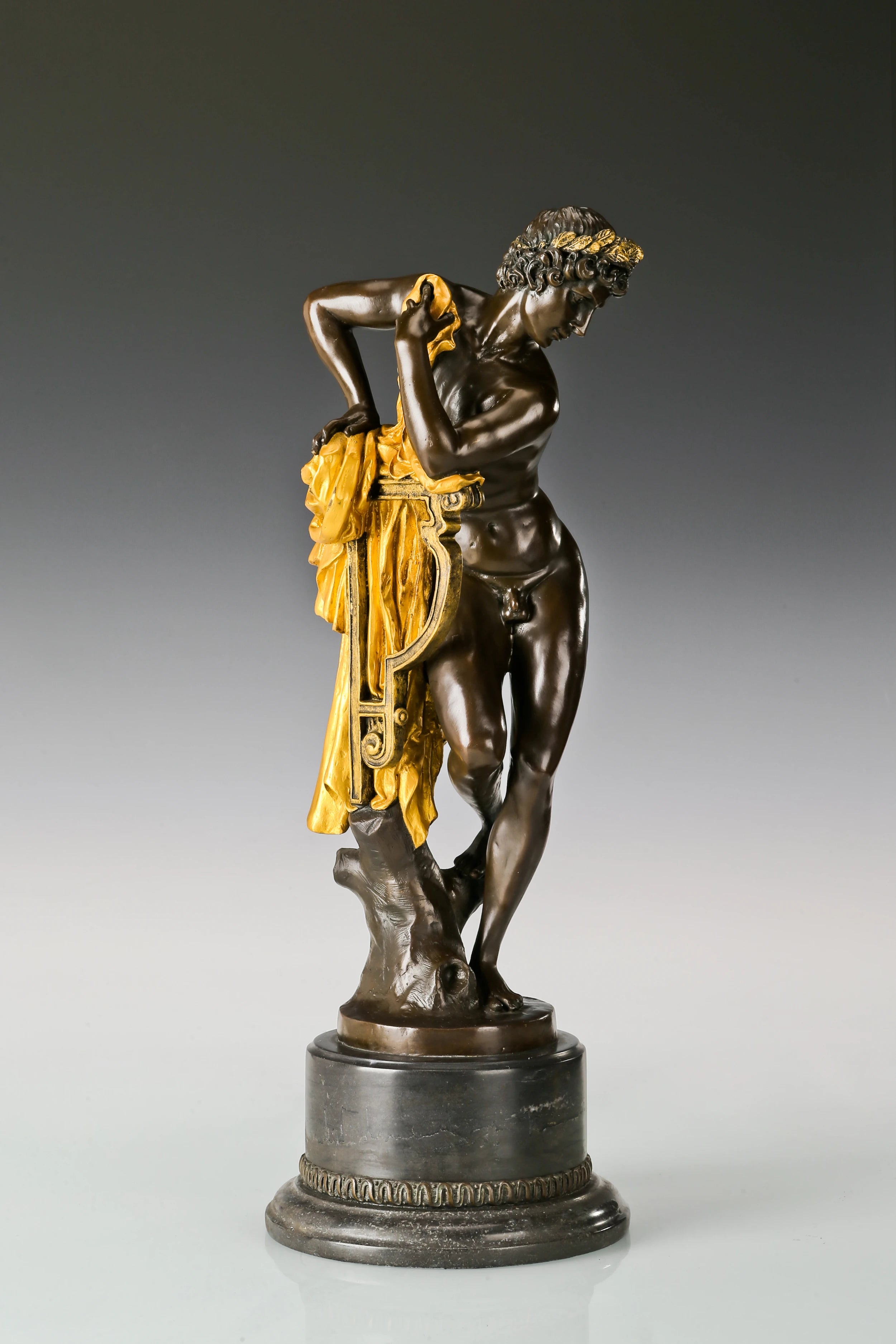 Three quarter view of classical Apollo bronze statue with lyre