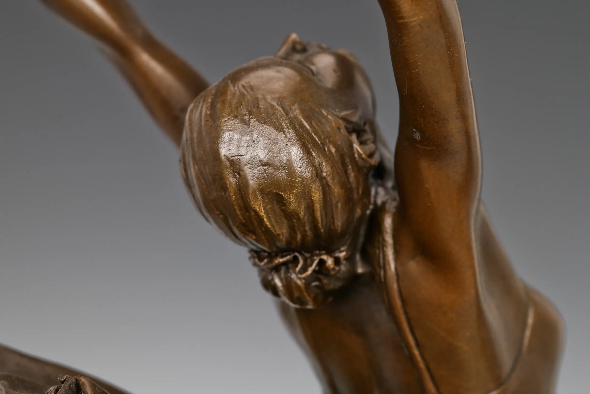 Close-up of the bronze ballerina figure with gracefully extended arms