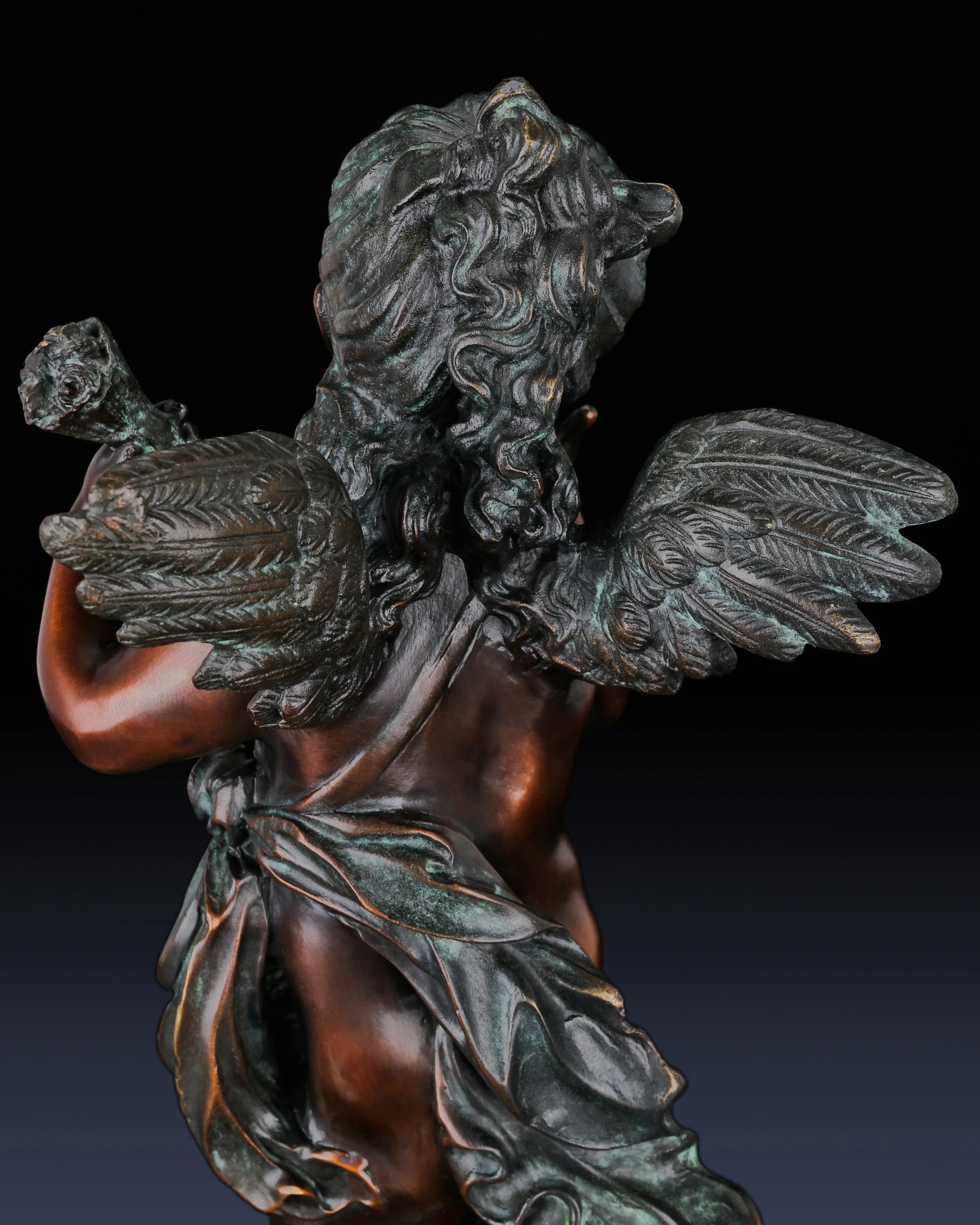 Detailed view of flowing drapery and hand-applied patina on bronze cherub sculpture