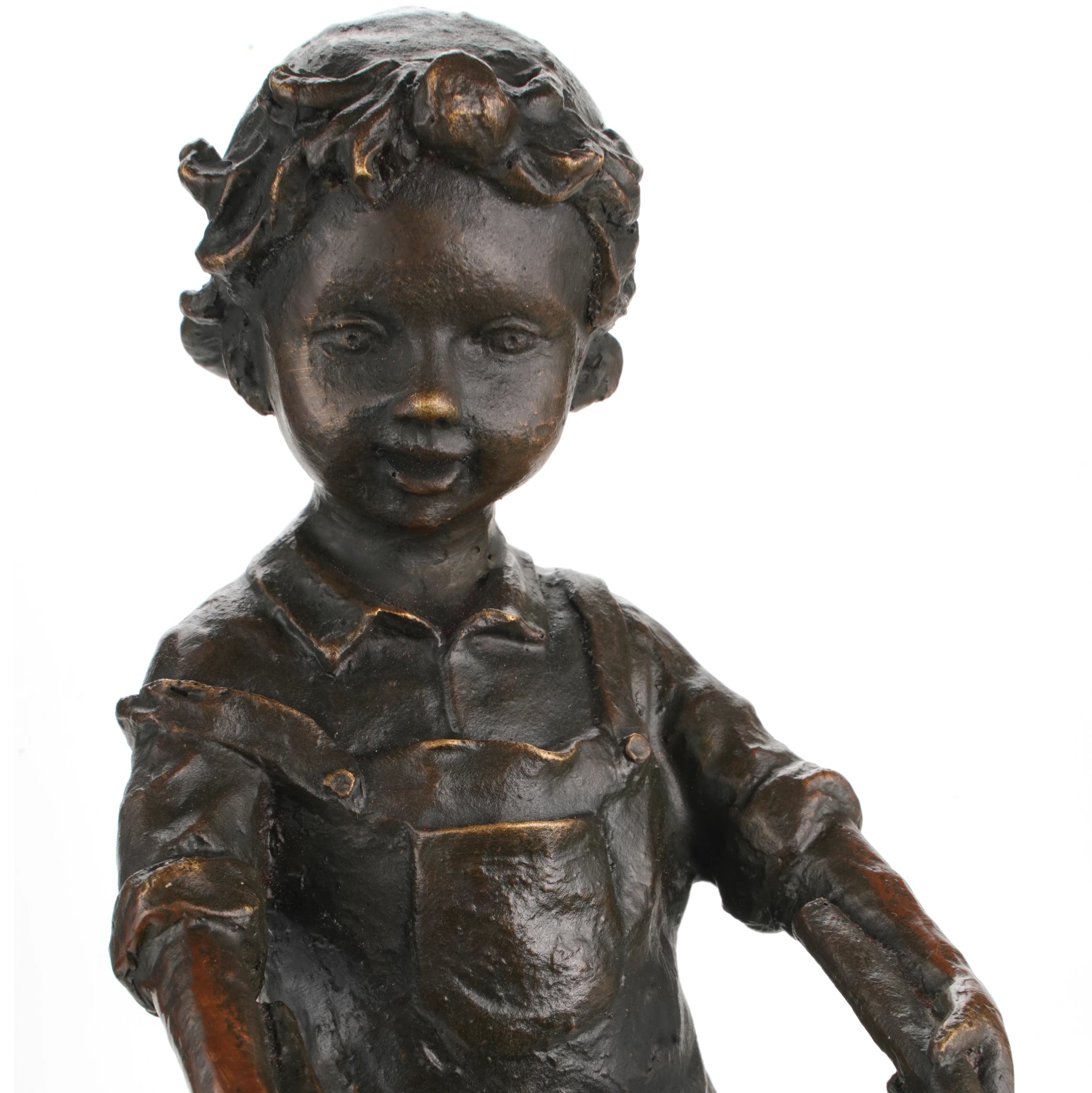 Close-up detail of bronze children sculpture showing facial expressions, clothing, and wheelbarrow texture.