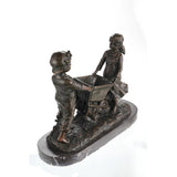 Right side view of handcrafted bronze boy and girl wheelbarrow sculpture.