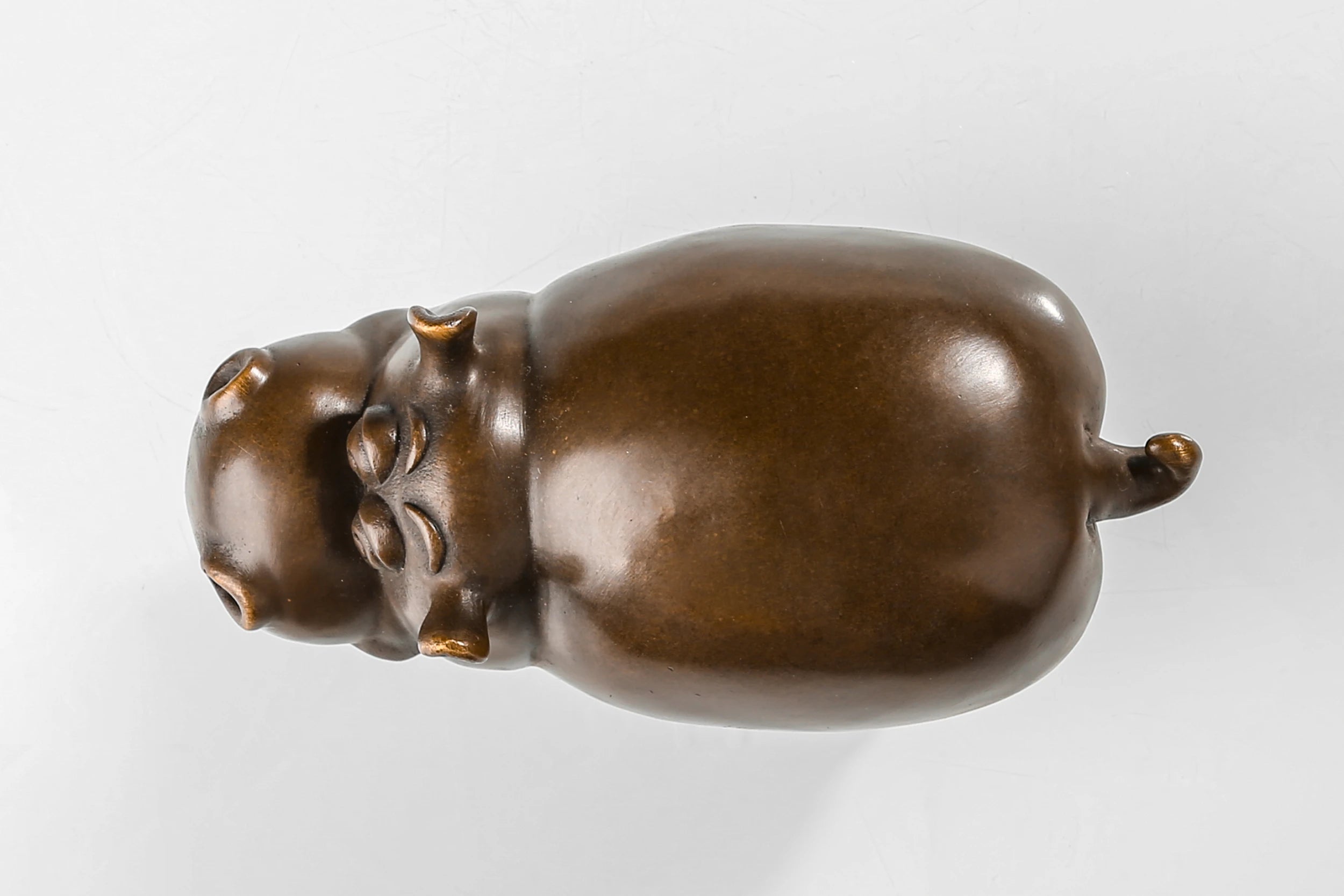 Detailed view of the handcrafted bronze texture and smooth finish of the cute cow sculpture.