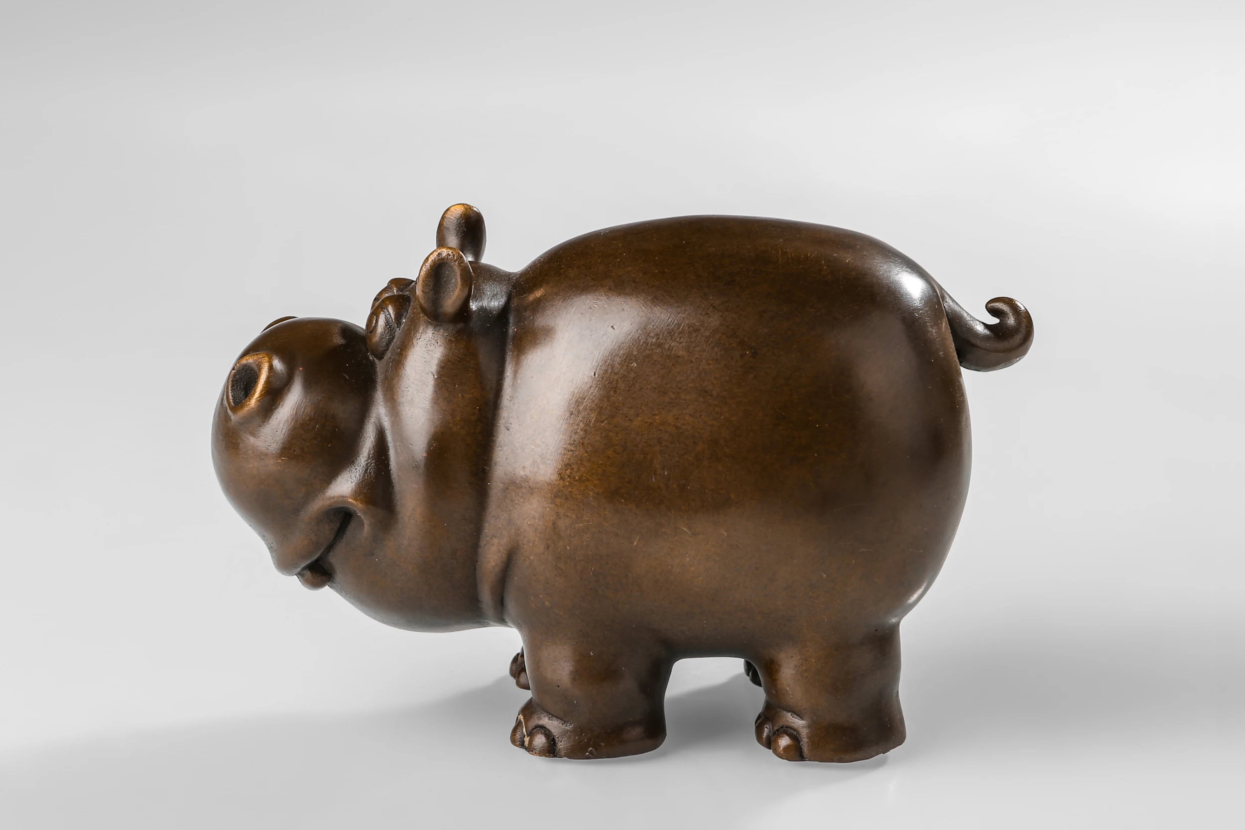 Left side view of a cute bronze cow
 sculpture for shelf and desk decor.