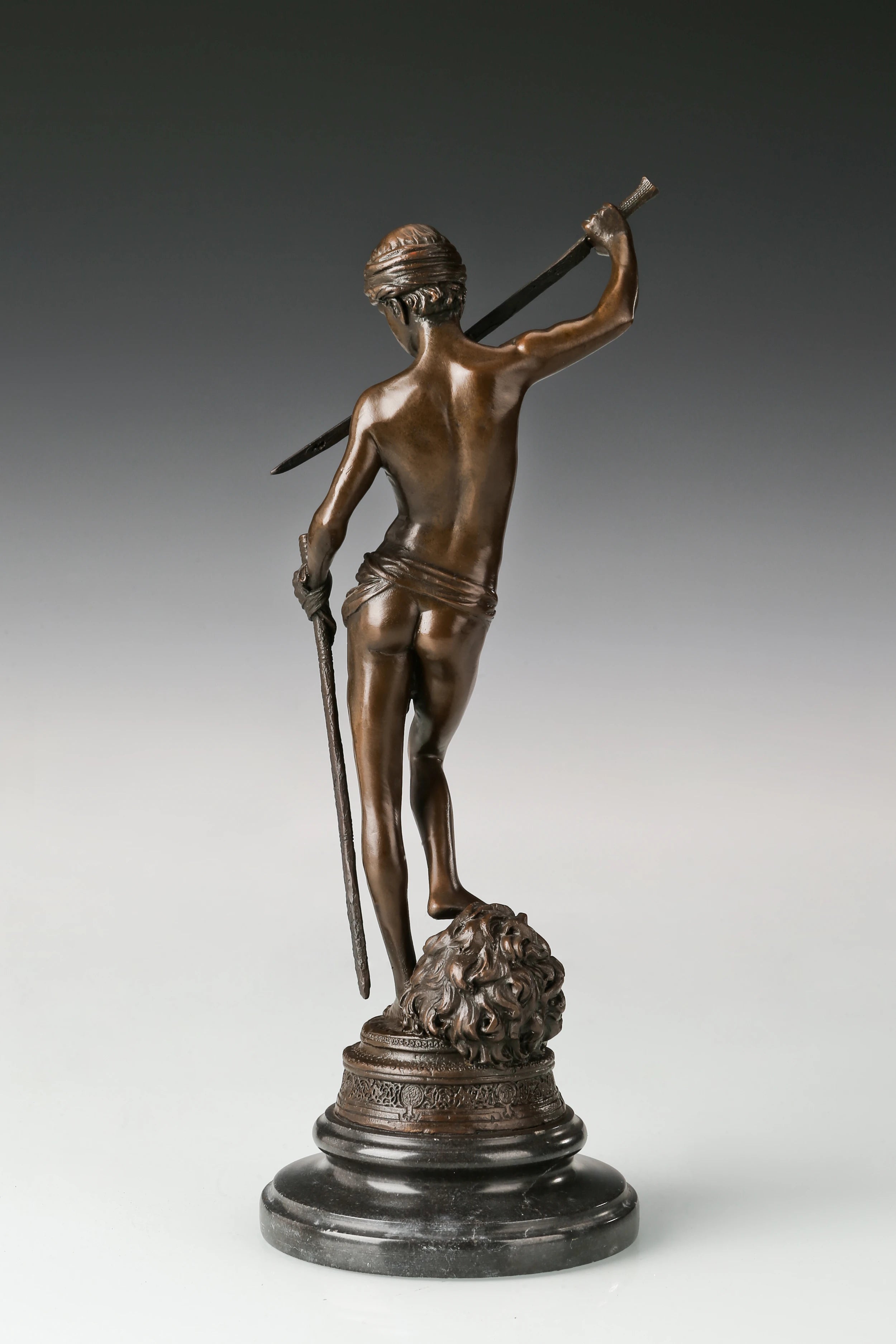 Rear view of bronze David and Goliath sculpture showing detailed anatomy