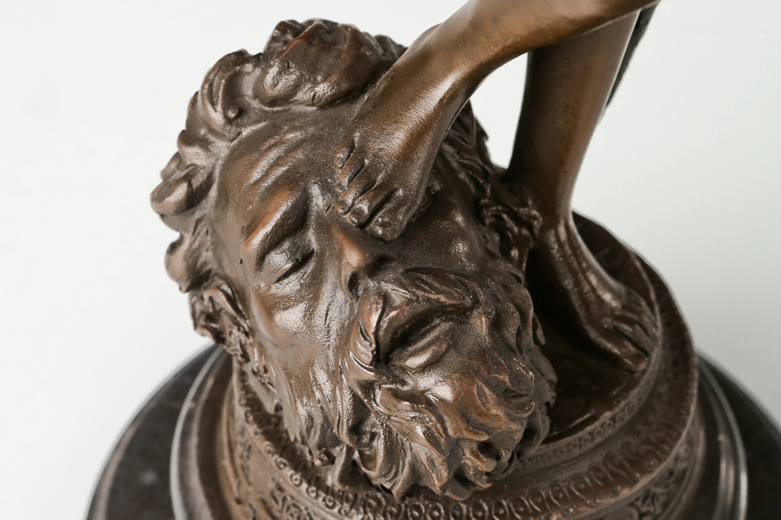 Detailed bronze Goliath head beneath David's foot
