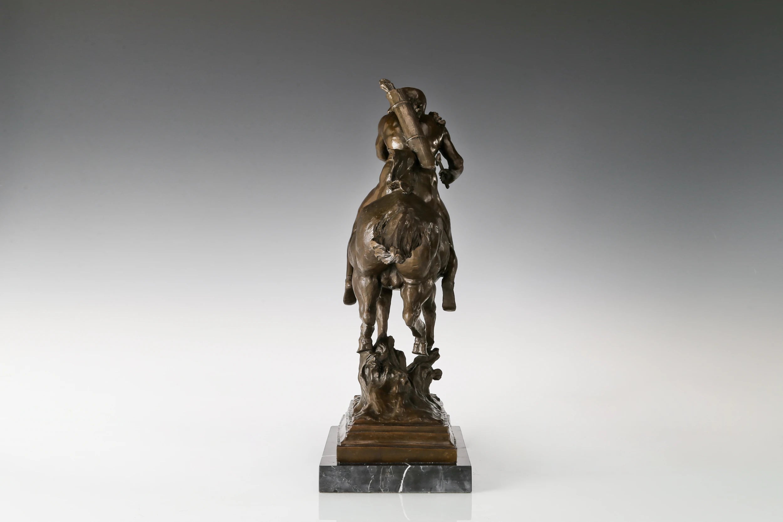 Rear view of bronze equestrian sculpture highlighting the horse mane tail and rider details