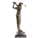 Rear view of a bronze female golfer statue highlighting the follow-through pose and detailed golf attire.