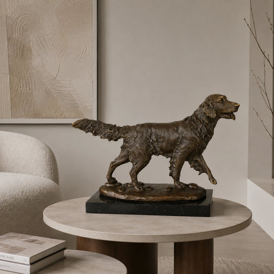 A dynamic bronze golden retriever statue  in mid-stride on pebbled ground, featuring a warm patina and wavy coat texture for home office or library decor.