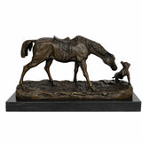 Handcrafted bronze horse and dog sculpture showing a saddled horse gently approaching a small dog