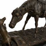 Close-up of bronze horse head lowered gently toward the small dog