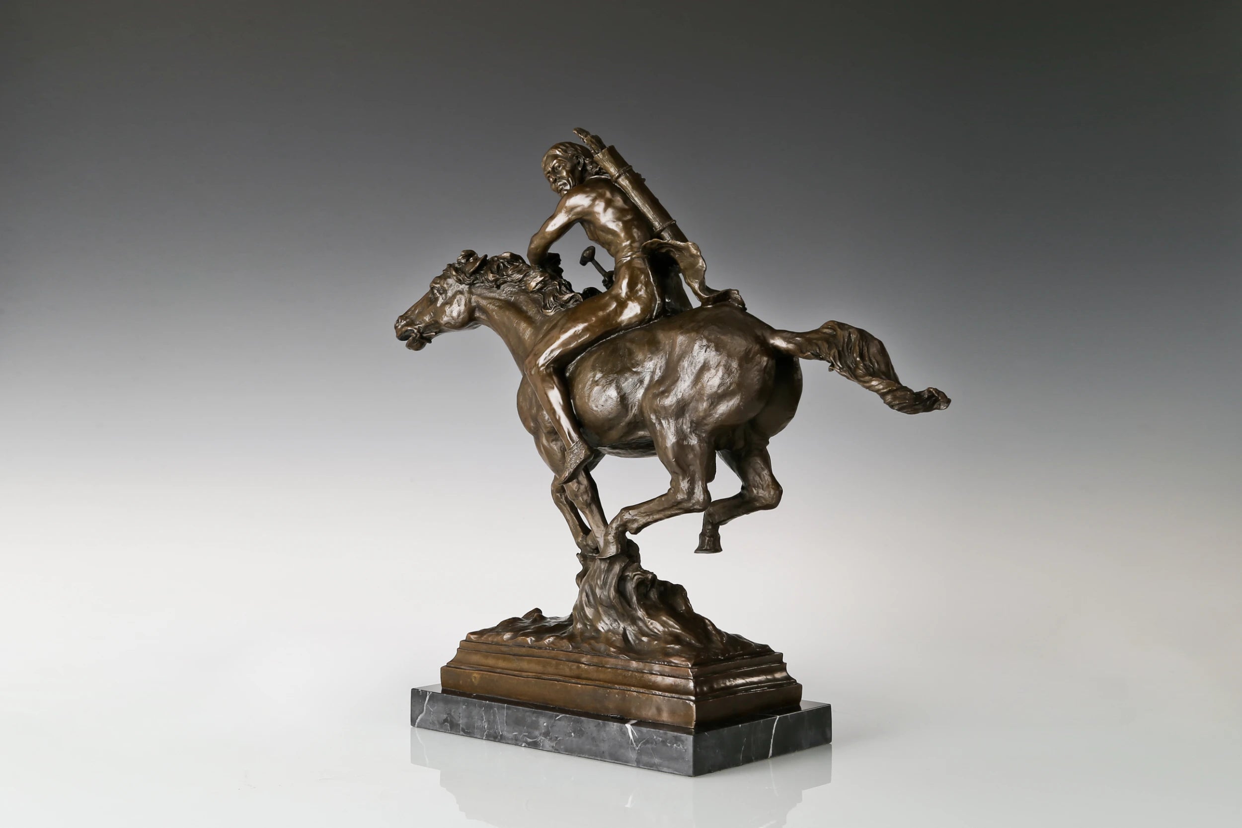 Three-quarter view of bronze horse rider sculpture showing dynamic galloping movement