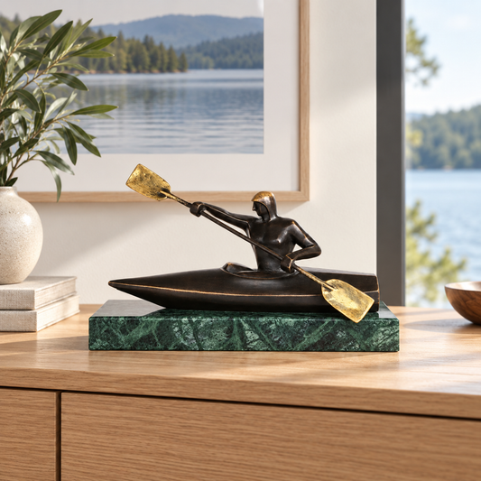 Abstract bronze kayaker statue with paddle displayed as modern water sports and office decor