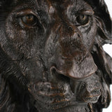 Close-up of bronze lion sculpture showing expressive face eyes and deeply textured mane