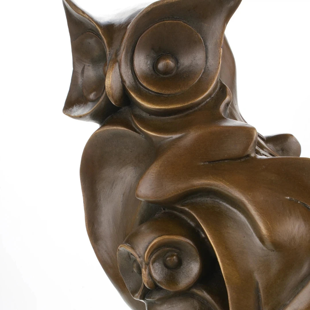 Close-up of bronze owl sculpture showing large expressive eyes and stylized facial details