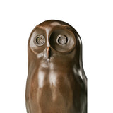 Close-up of bronze owl sculpture showing oversized circular eyes and minimalist facial details