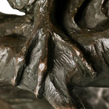 Detailed view of bronze owl talons gripping a naturalistic textured tree branch