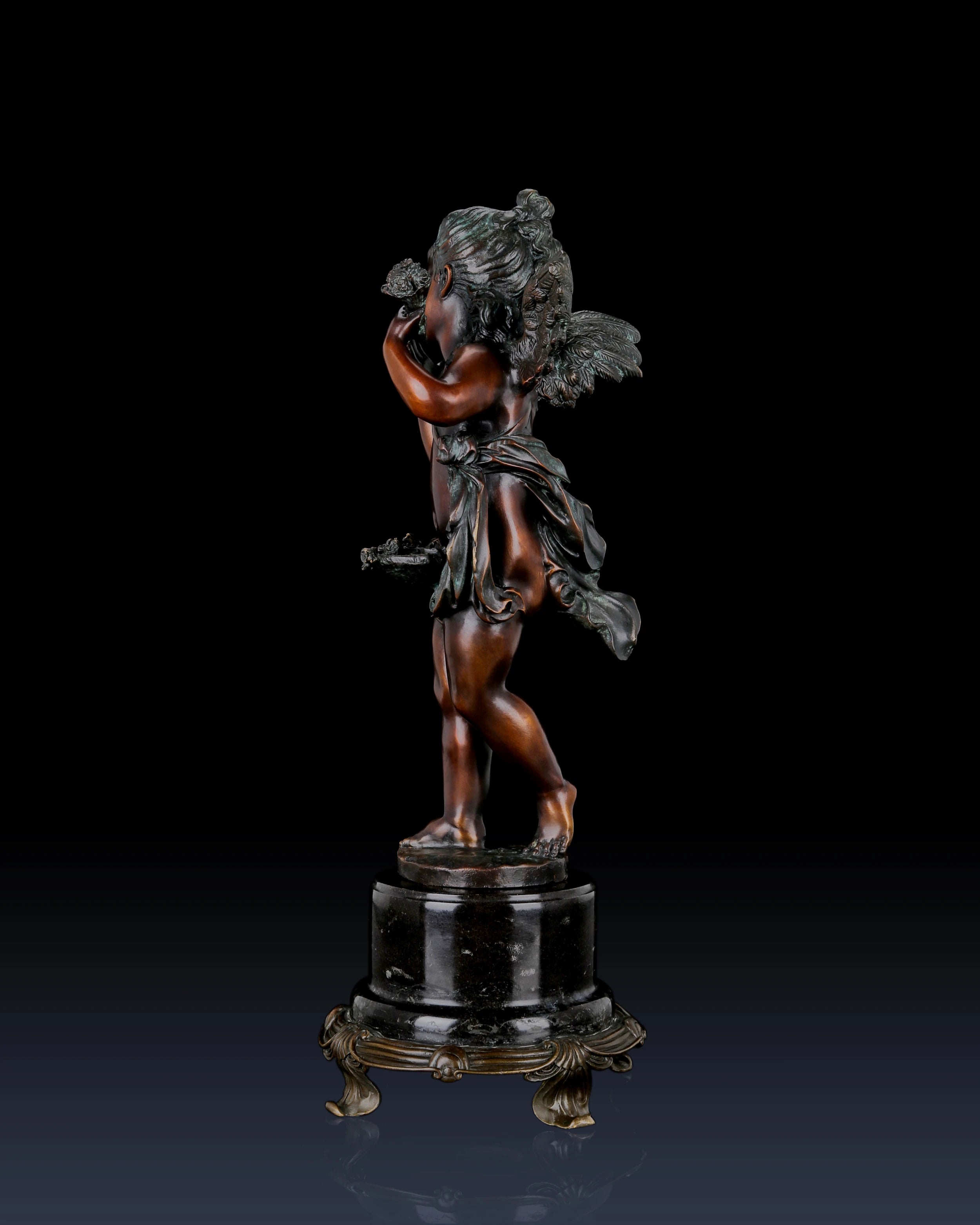 Left side view of handcrafted bronze Putto sculpture showing flowing drapery and sculpted details