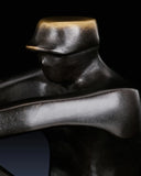 Close-up of seated sailor figure on handcrafted abstract bronze sailing sculpture