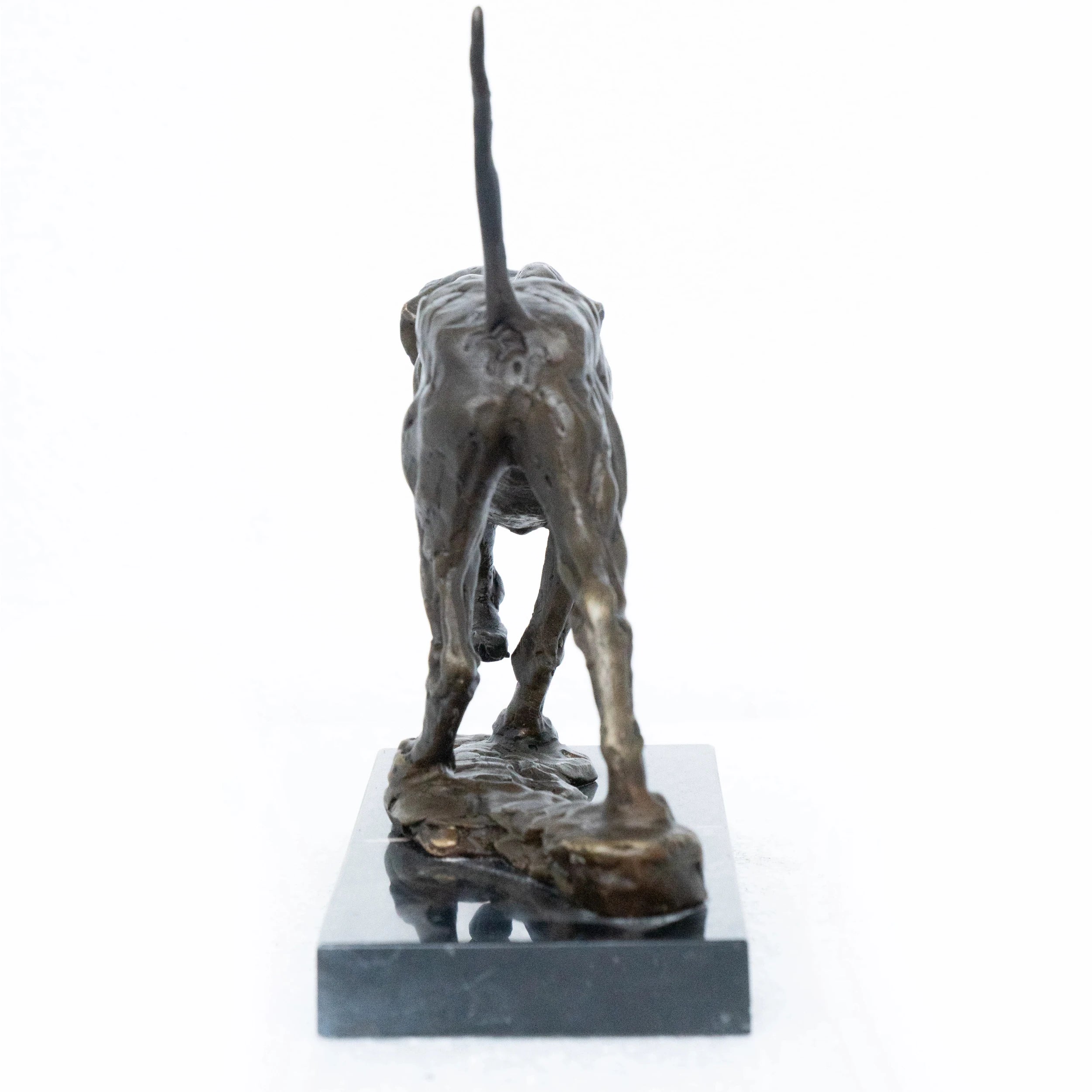 Close-up of bronze hunting dog showing lowered head, detailed collar, and raised tail