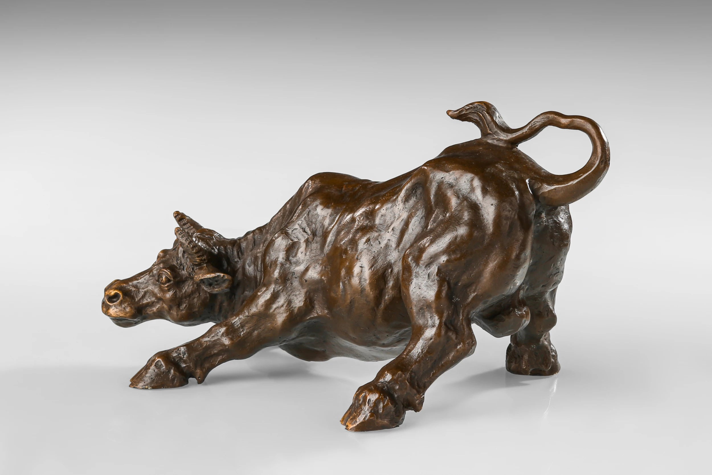 Wall Street charging bull bronze sculpture in a powerful pose, realistic bull market statue on black marble base, loss wax casting fine art.