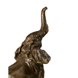 Playful elephant calf bronze sculpture with raised trunk and textured patina. A charming wildlife statue symbolizing joy, luck, and new beginnings.