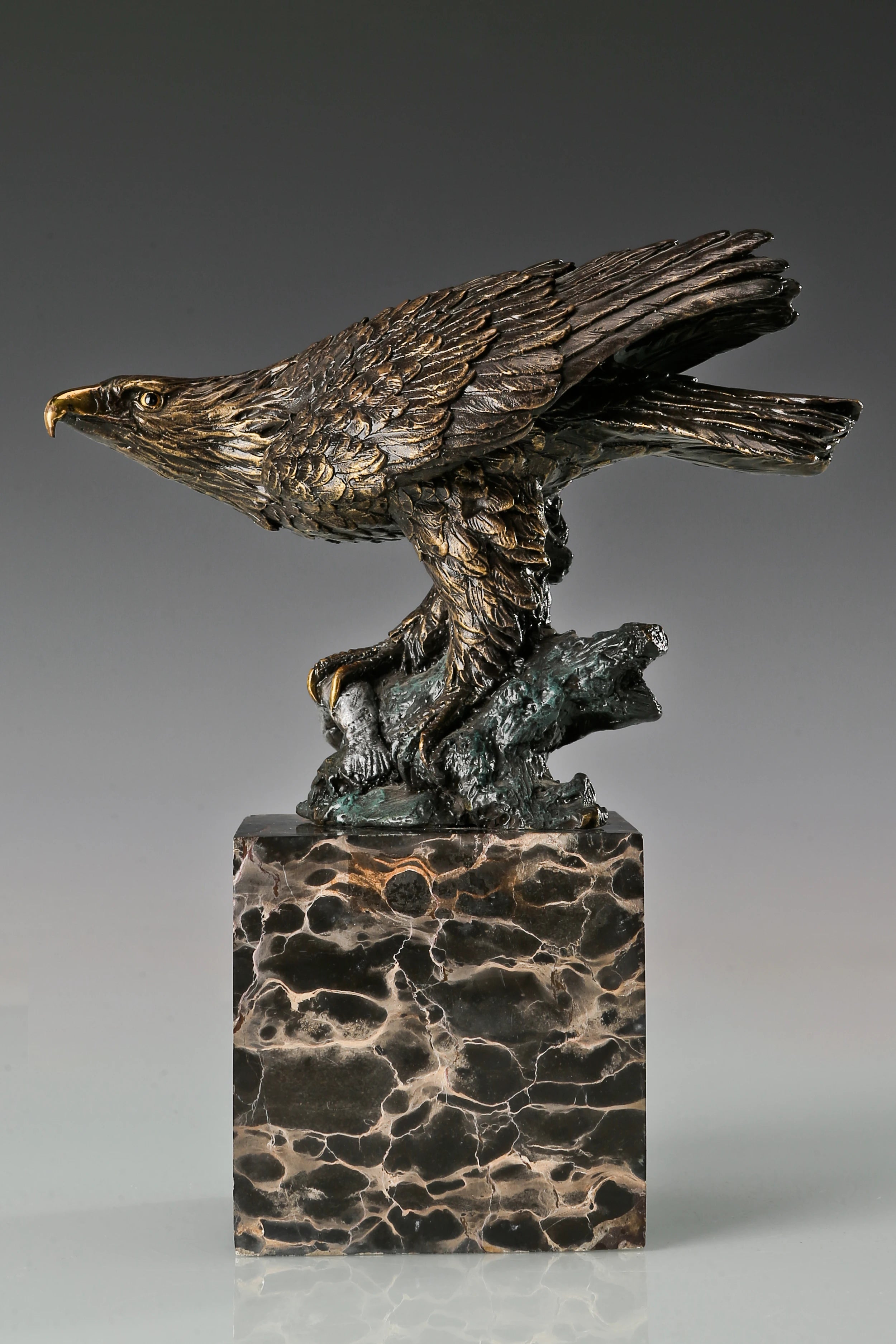 Pre-flight bronze eagle sculpture with detailed feathers and natural base. Elegant wildlife statue for home decor, office, or collectors.