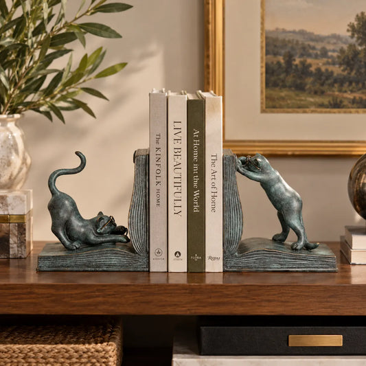 Cat bronze bookends displayed with books on a modern bookshelf