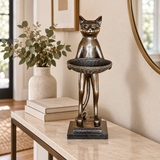 Cat Holding Tray bronze sculpture displayed in a minimalist interior