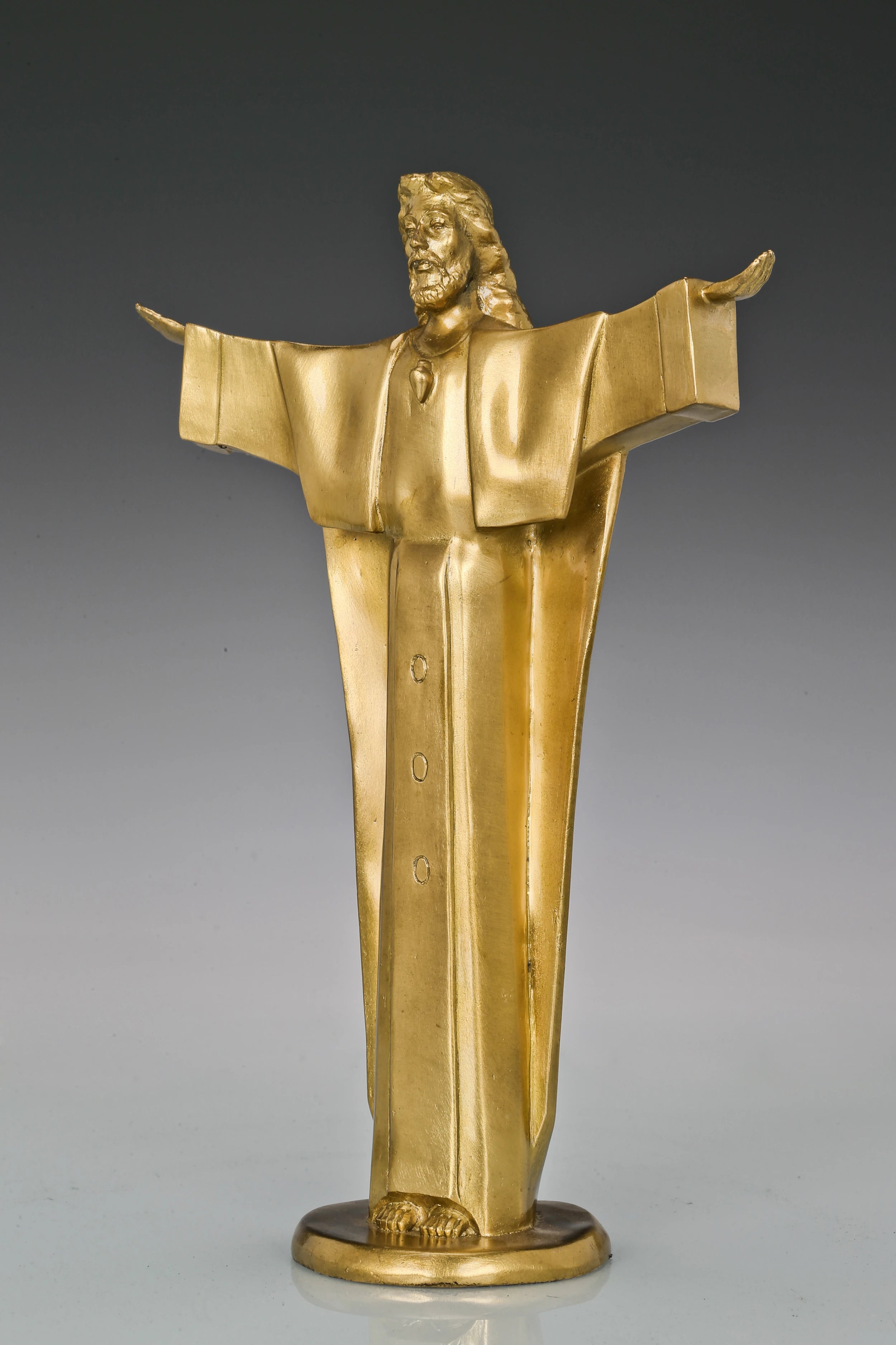Left side view of Christ the Redeemer bronze statue showing extended arm and flowing robe