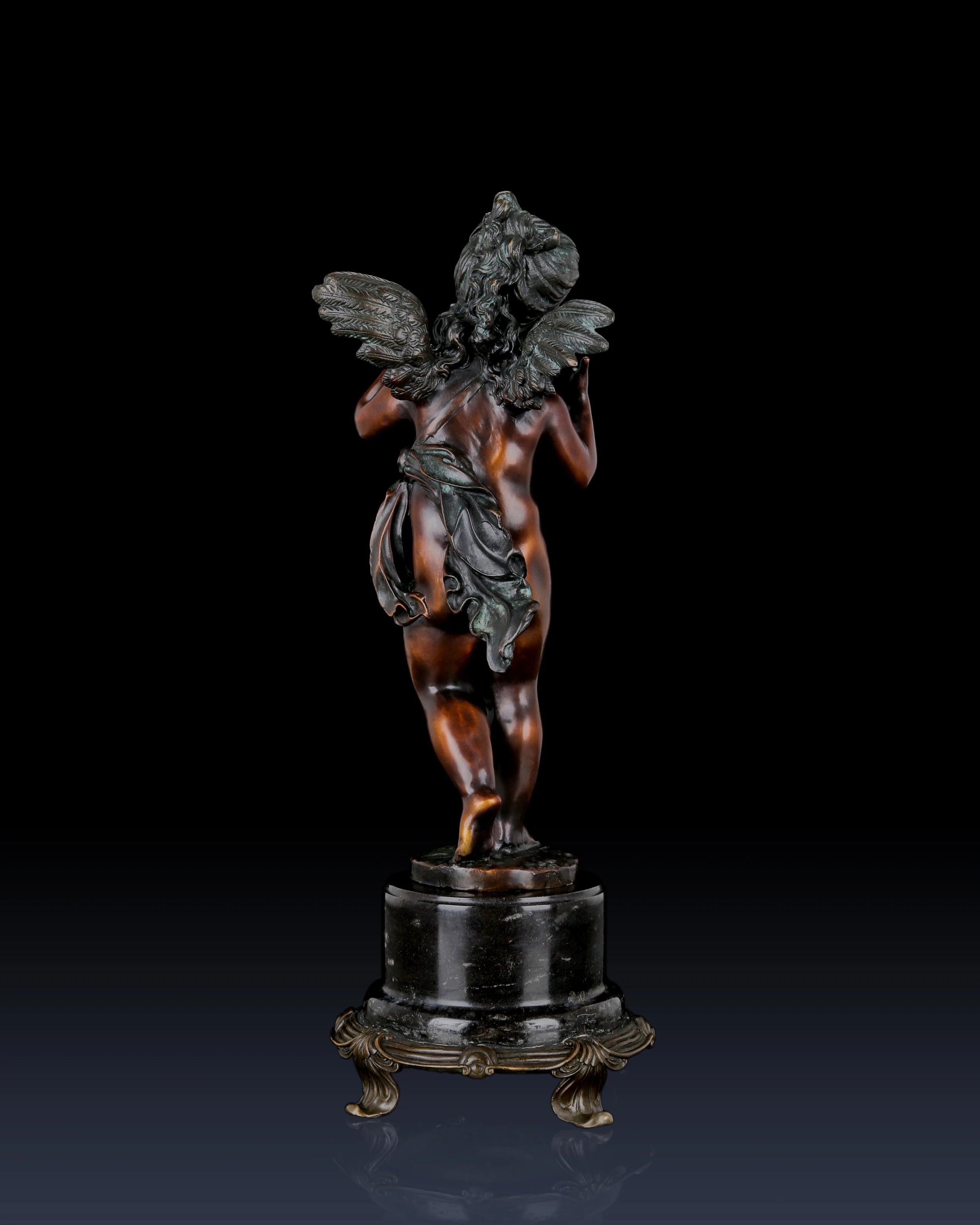 Rear view of classical bronze Putto sculpture highlighting hair, drapery, and figure details
