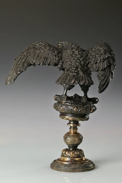 Elegant bronze eagle sculpture with ornate pedestal and detailed feathers. A refined statement piece symbolizing strength, control, and authority.