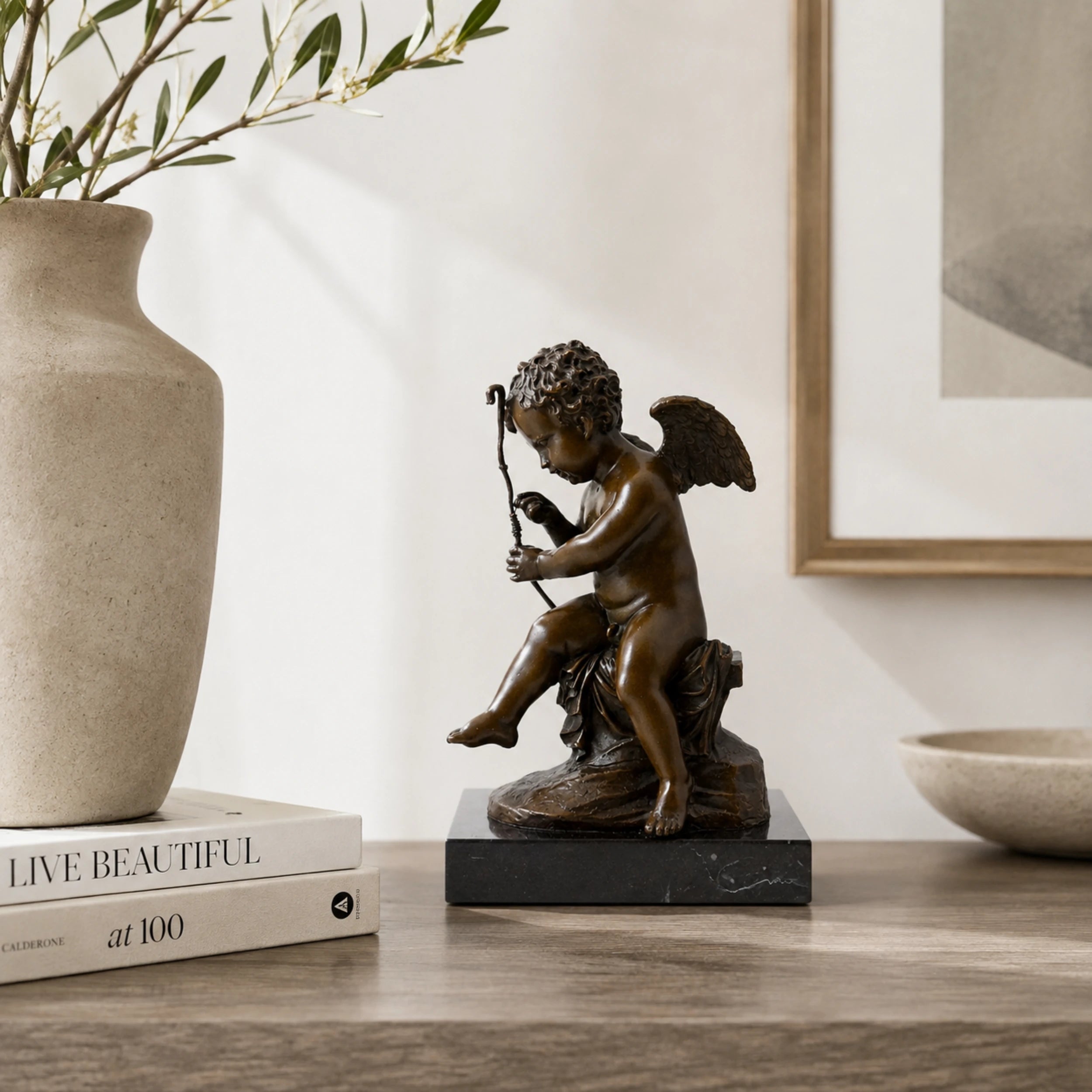 Cupid repairing his bow bronze sculpture displayed as elegant romantic home decor