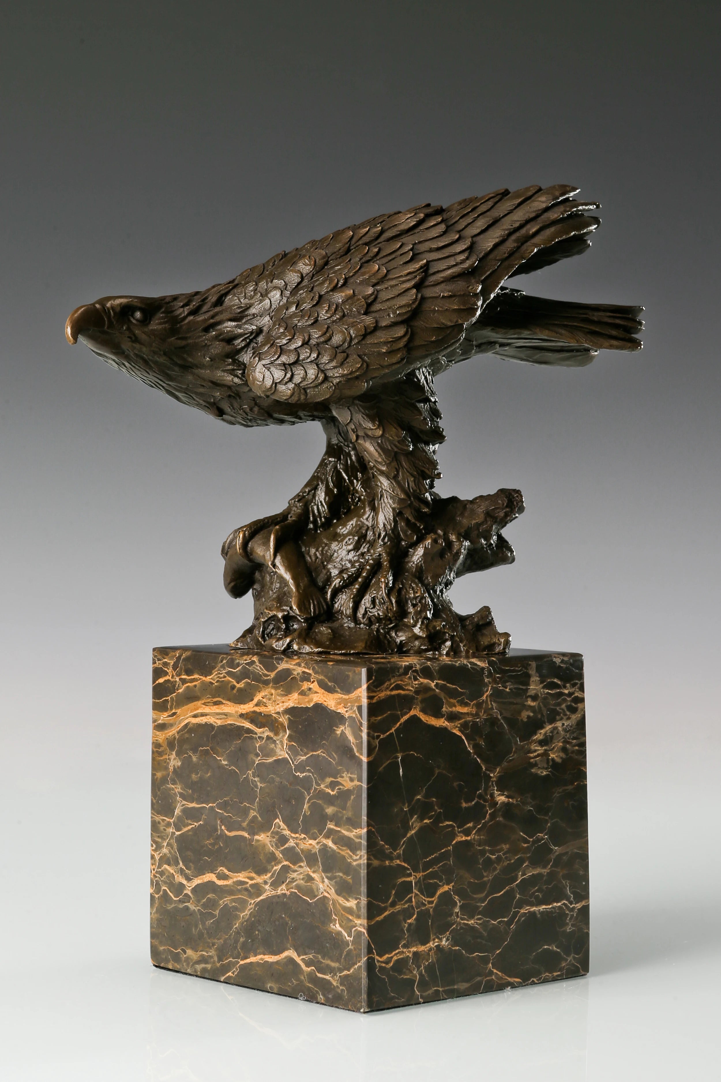 Pre-flight bronze eagle sculpture with detailed feathers and natural base. Elegant wildlife statue for home decor, office, or collectors.