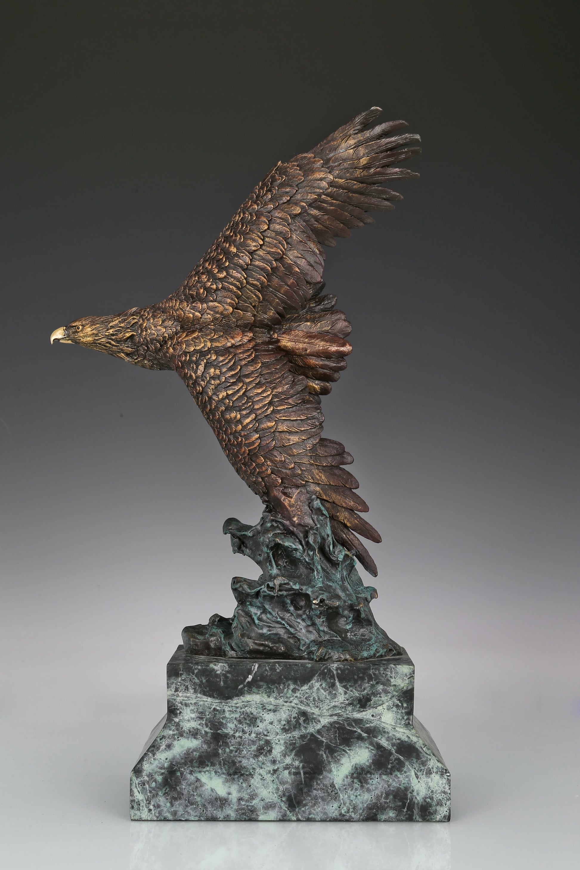 Bronze eagle sculpture with wings spread, capturing a powerful takeoff moment. A bold statue symbolizing strength, freedom, and ambition.