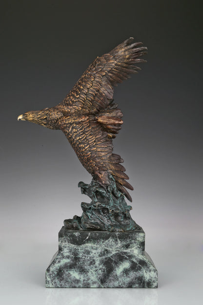 Bronze eagle sculpture with wings spread, capturing a powerful takeoff moment. A bold statue symbolizing strength, freedom, and ambition.