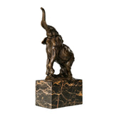 Playful elephant calf bronze sculpture with raised trunk and textured patina. A charming wildlife statue symbolizing joy, luck, and new beginnings.