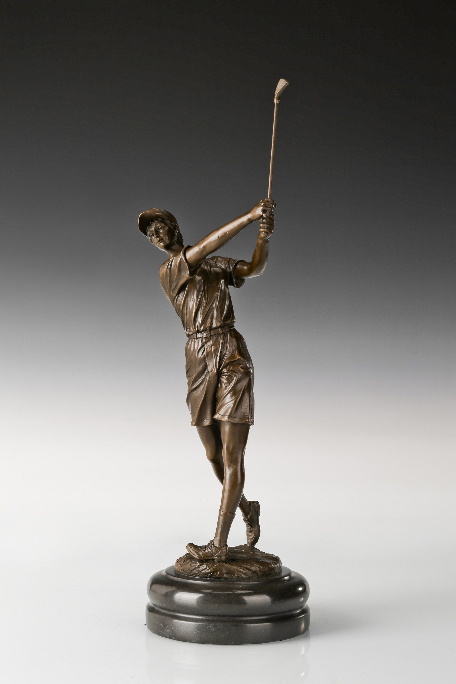 Close-up of the female golfer's face, cap, and hand-finished bronze patina