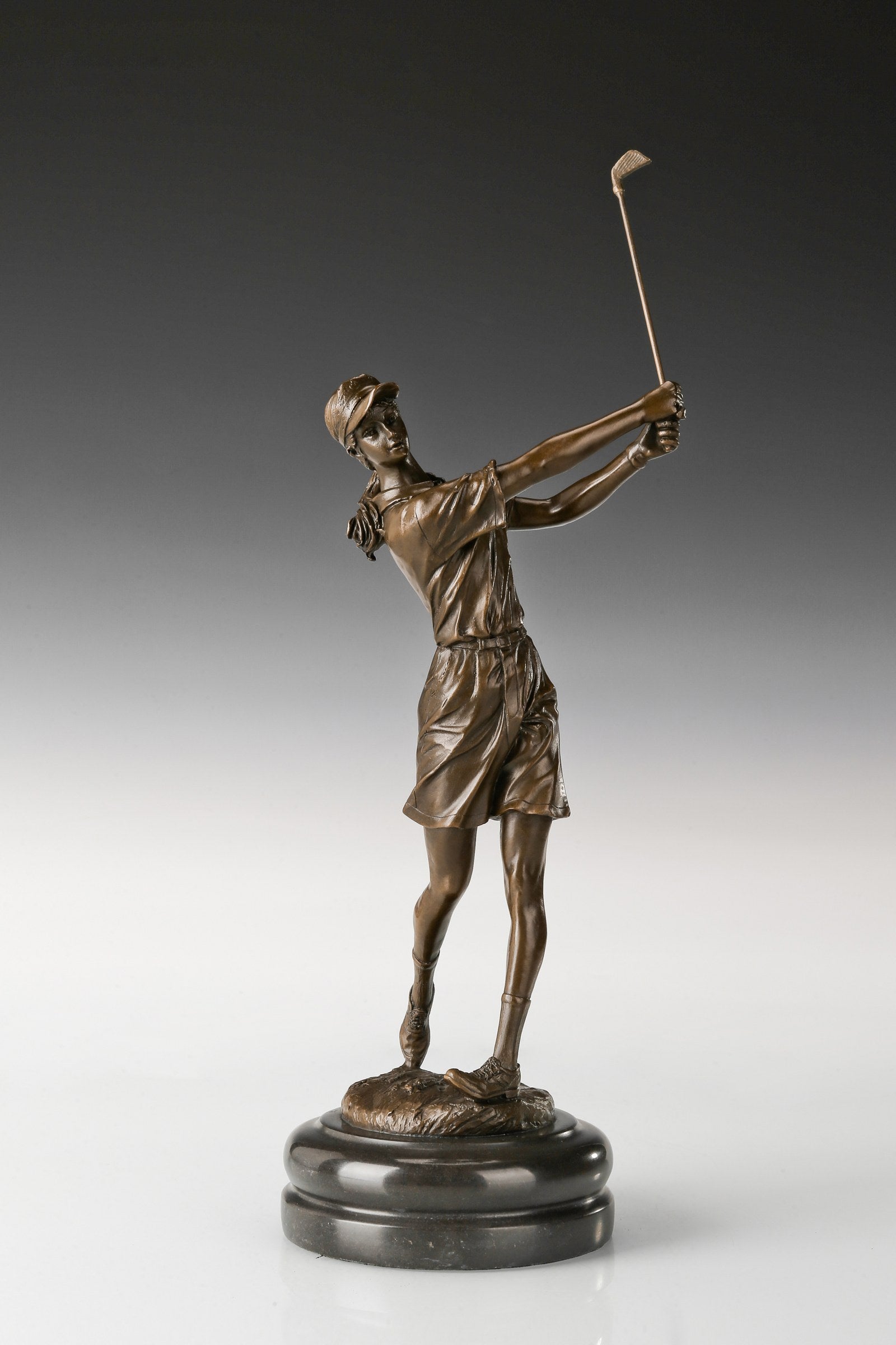 Female golfer bronze sculpture in a raised-club follow-through pose, front view