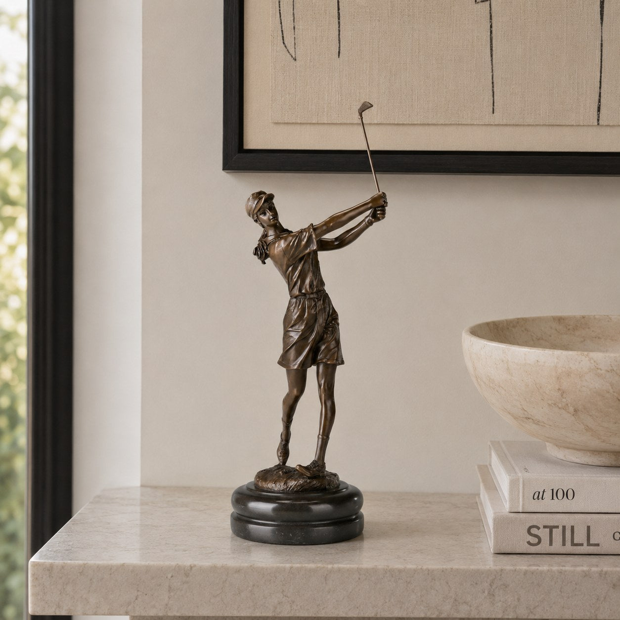 Female golfer bronze sculpture displayed on a console table in a modern interior
