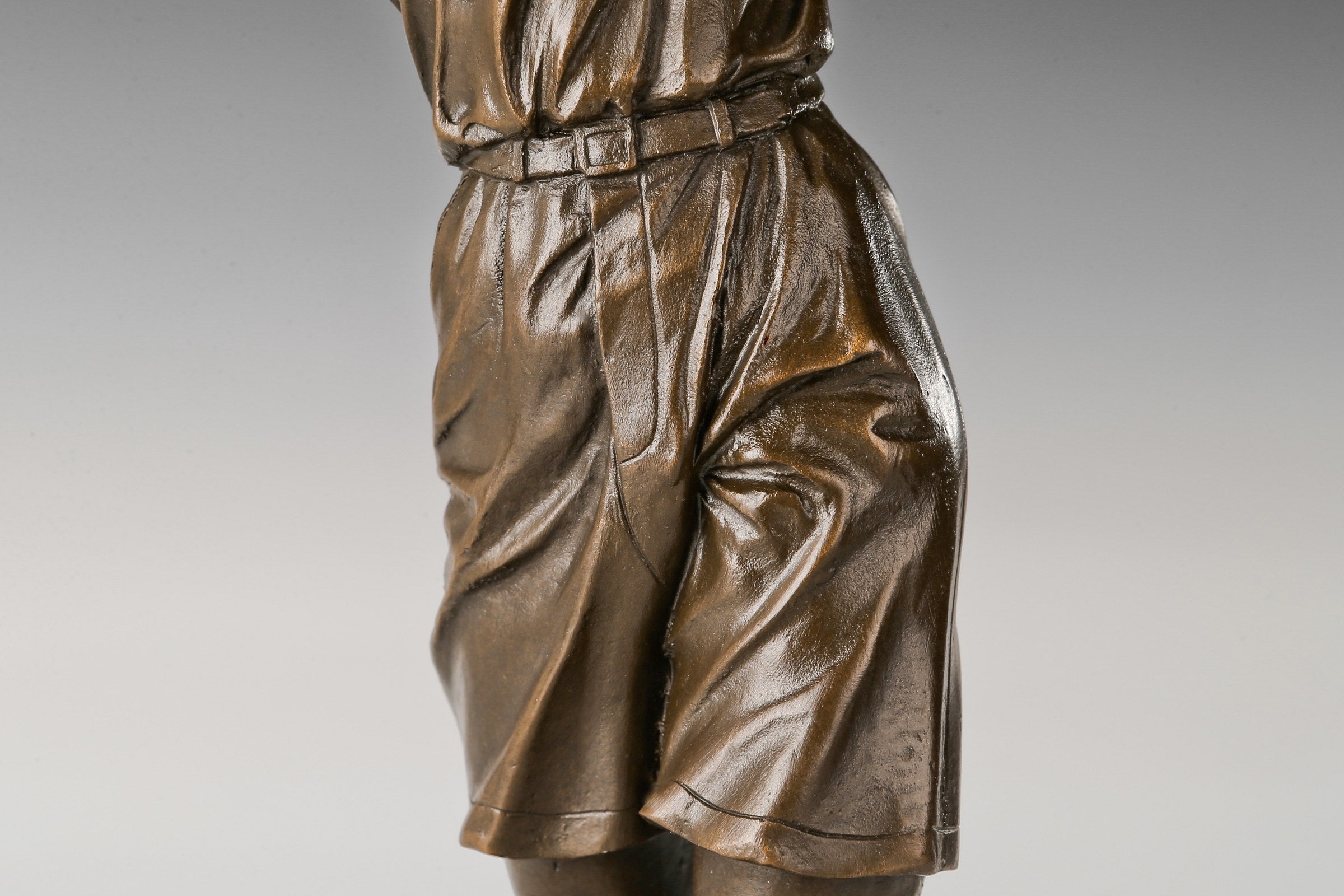 Rear-right view of female golfer bronze sculpture and flowing clothing detail