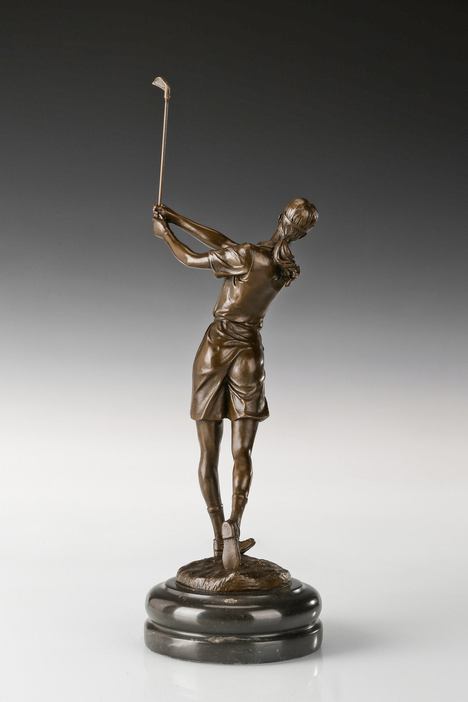 Female golfer bronze sculpture in follow-through pose, three-quarter front view