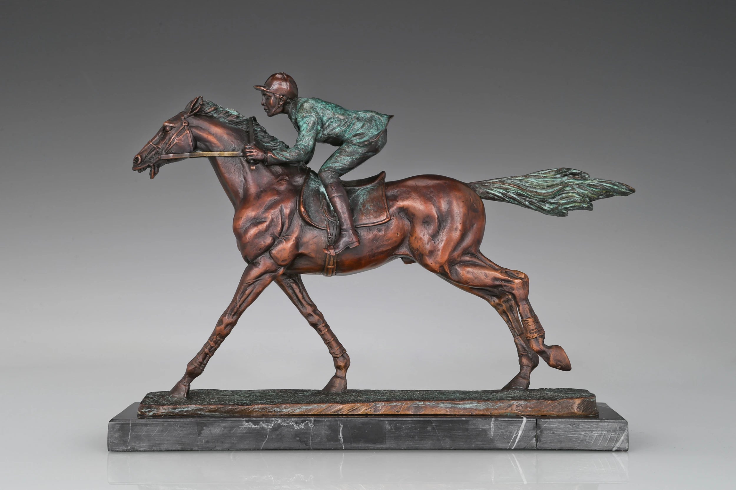 Racehorse and jockey bronze sculpture with green patina finish and dynamic racing composition