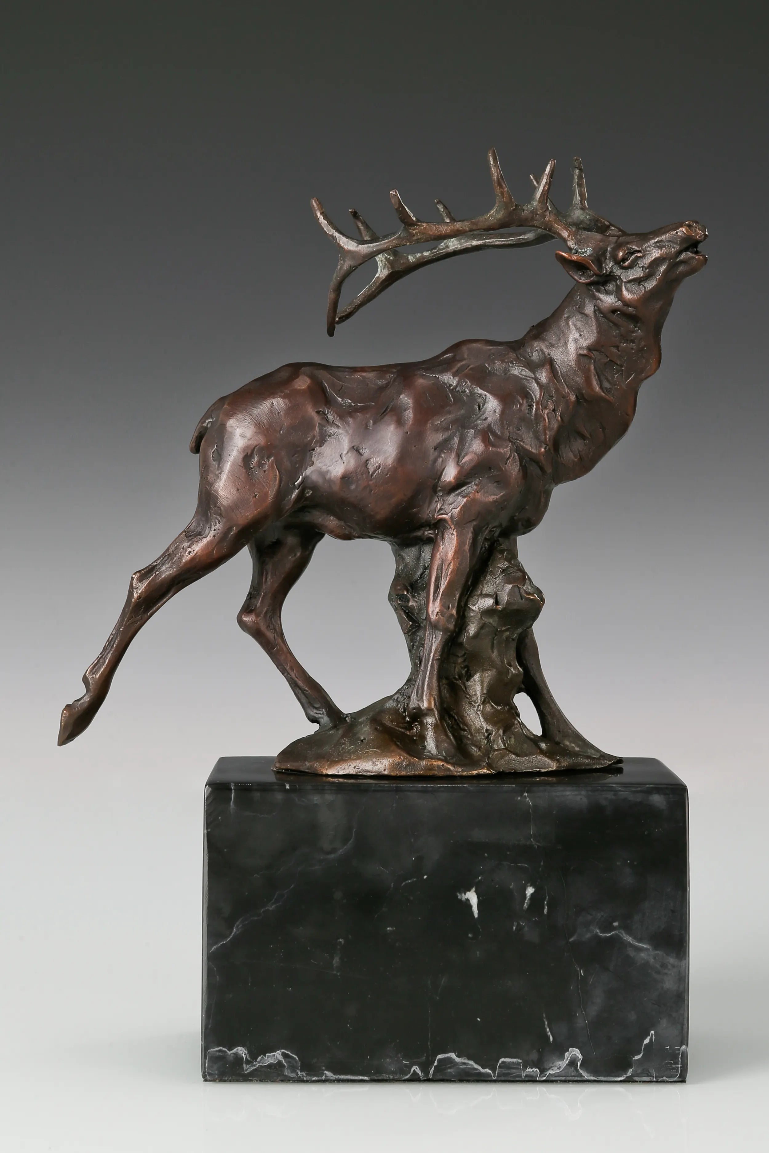 Handcrafted bugling elk bronze statue with large branching antlers and marble base, ideal for offices, studies, cabins, lodges and wildlife-inspired interiors.