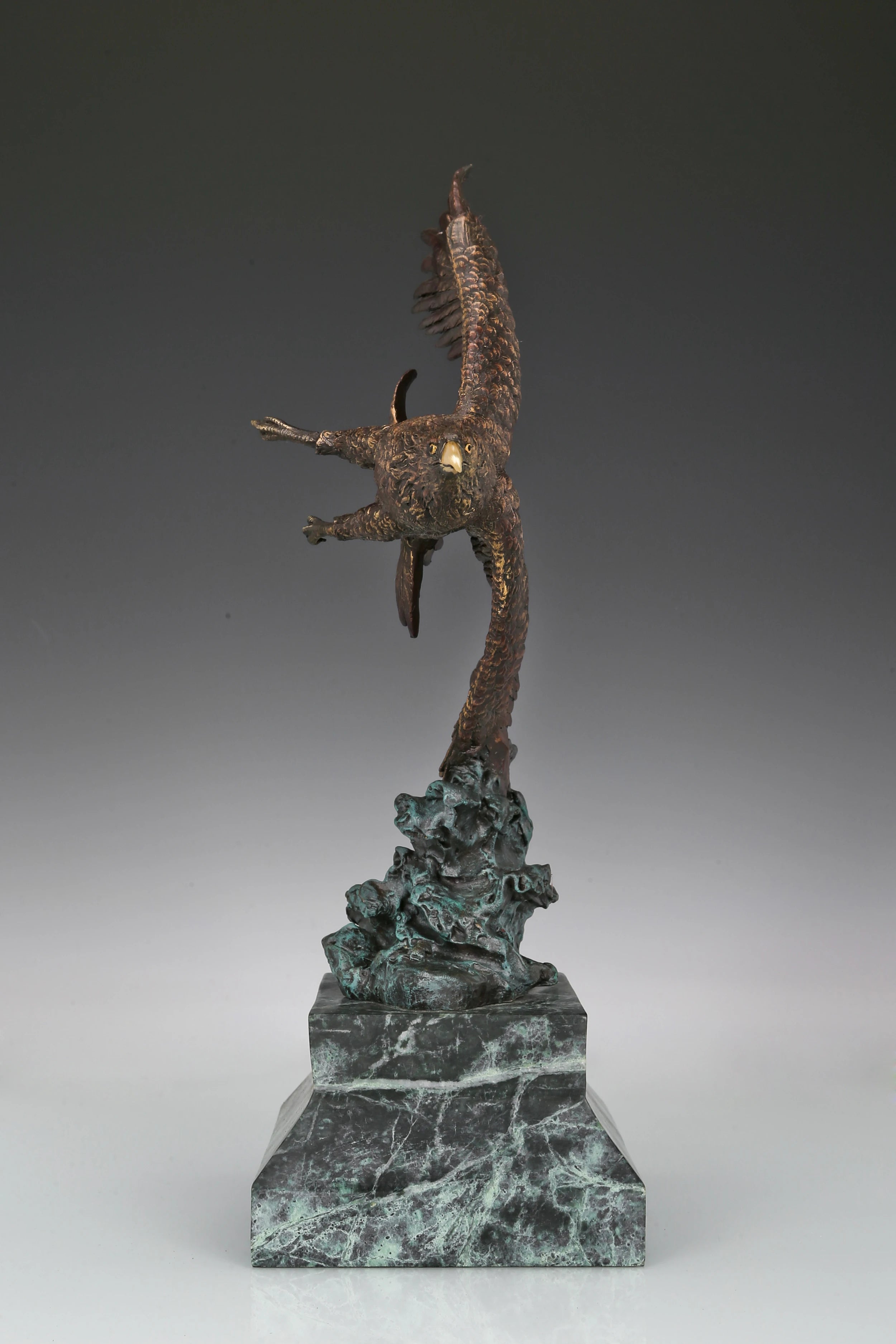 Bronze eagle sculpture with wings spread, capturing a powerful takeoff moment. A bold statue symbolizing strength, freedom, and ambition.